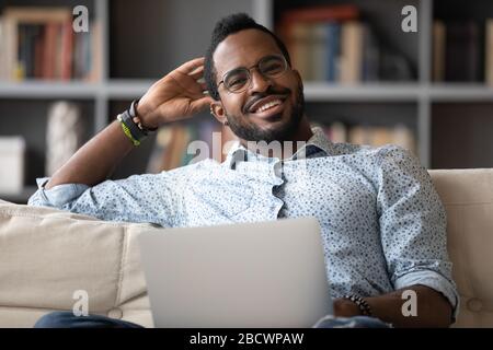 Portrait of smiling biracial man using modern laptop Stock Photo