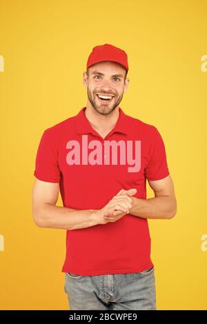 Shop worker. Handsome guy cashier uniform. Restaurant cafe staff wanted. Welcome. Supermarket cashier. Man delivery service wear red cap. Shop assistant. Food order delivery man. Cashier occupation. Stock Photo