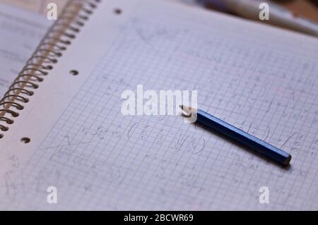 Closeup of a notebook full of math operations next to pencil of a high school student preparing for college entrance exams Stock Photo