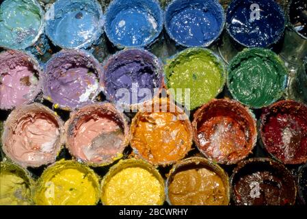 Cans of paint open for use in artist's  studio Stock Photo