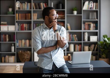 Pensive african American man look in distance dreaming Stock Photo