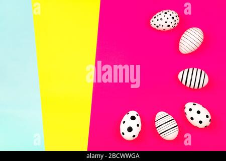 Different graphic hand-painted eggs on bright pink background. Easter concept. Place for text. Stock Photo