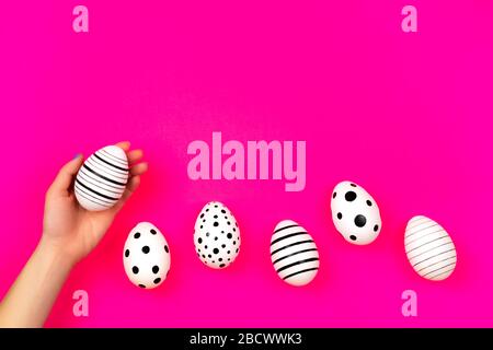 Different graphic hand-painted eggs on bright pink background. Easter concept. Place for text. Stock Photo