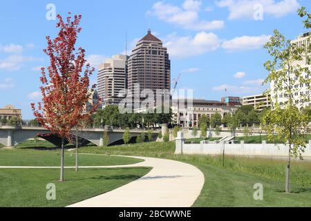 Alexander park Downtown Columbus Ohio green landscape with green trees, concrete walk way , colorful trees city skyline structure ,blue sky Stock Photo