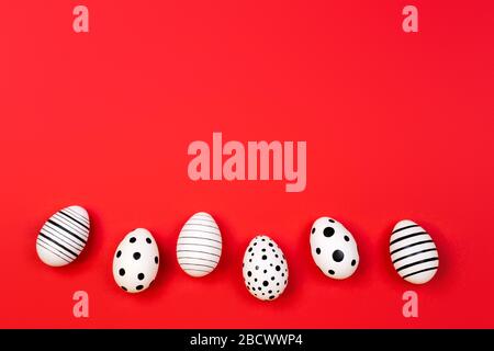 Different graphic hand-painted eggs on trendy coral background. Easter concept. Place for text. Stock Photo