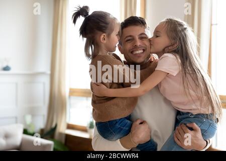 Cheerful daddy holding adorable little children siblings. Stock Photo