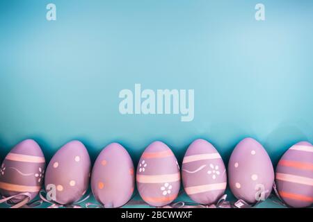 Beautiful decorative grey eggs in a row on blue pastel background. Easter concept. Place for text. Stock Photo
