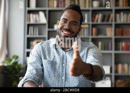 Portrait of smiling biracial man welcome new employee at workplace Stock Photo