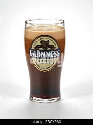 Montreal, Canada - March 15, 2020: An originall Guinness glass of dark stout beer. Guinness is a dark Irish dry stout that originated in the brewery o Stock Photo