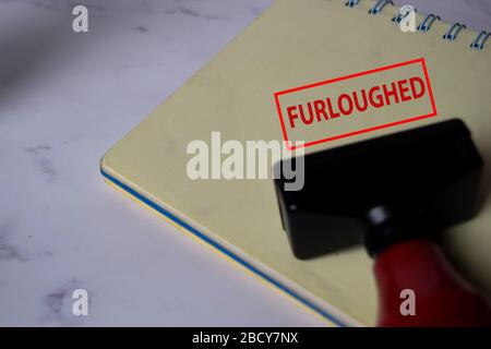 Red Handle Rubber Stamper and Furloughed text isolated on White Background. Stock Photo