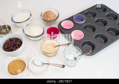Bran muffins with dry cranberries recipe. Bran, flour, buttermilk, dry berries, and some other ingredients close up on a kitchen table Stock Photo