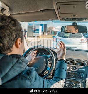 a man uses a horn in a car upset from a traffic jam in the city Stock Photo