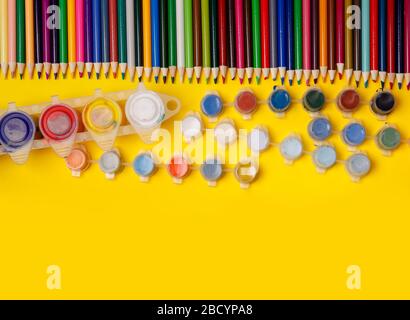 Overhead shot of stationery on yellow paper. Frame of school supplies Stock Photo