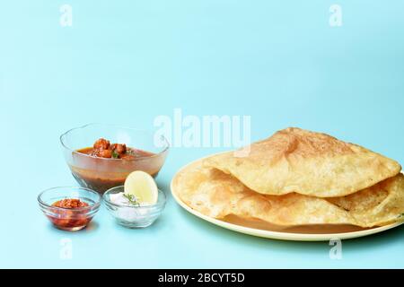 Indian dish spicy Chick Peas curry also known as Chole Bhatura and Chana Masala,traditional north indian lunch served with fried puri or flatbreads Stock Photo