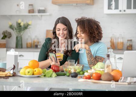 Best women friends talking at a table in the kitchen. Stock Photo