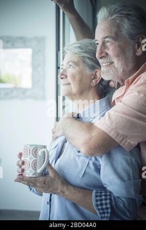 Beautiful senior caucasian couple at home enjoyig love and relationship - concept of coronavirus quarantine stayhome lockdown people - elderly and ret Stock Photo