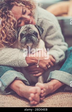 Love and friendship concept with happy defocused caucasian adult woman hug her lovely old dog pug - animal therapy and best friend together forever Stock Photo