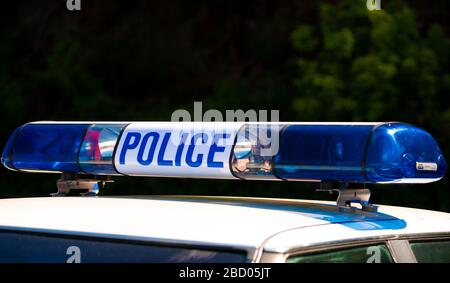 Police sign with blue lights, atop an emergency response patrol vehicle ...