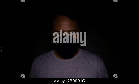 Mystery man wearing black mask. In black background Stock Photo