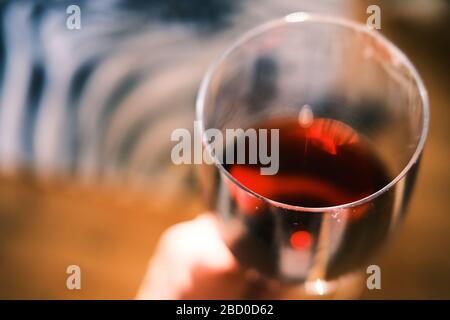A close up of a glass of red wine held in the hand Stock Photo