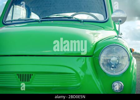 green little retro car. retro car concept. view of the front of the car and the headlight Stock Photo