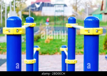 Parallel bars. Close-up photo on exercise machines in the park. against the background of a basketball court with people. healthy lifestyle concept Stock Photo