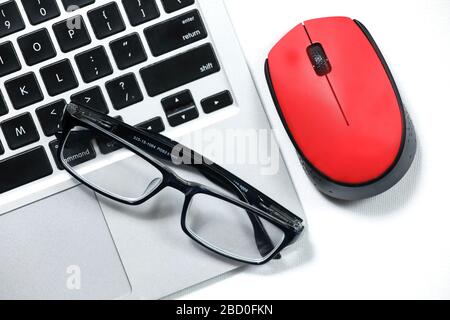 Black glasses on a laptop, red mouse isolated on a white background Stock Photo