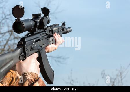 A man is holding a rifle aim and magazine camouflage clothes Stock Photo