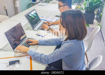 Office employees working on laptop in the office Stock Photo