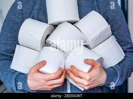 Man holds lots of toilet paper rolls close up Stock Photo