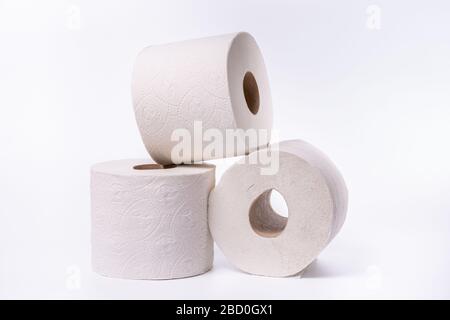 Three toilet paper rolls piled up on a white background Stock Photo