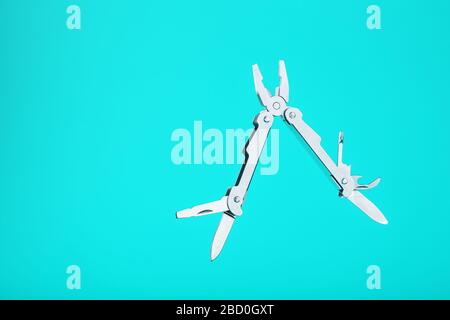 The multitool multi-function tool hovers on a blue background. The concept of an expanded multi-tool with free space. Stock Photo