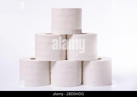 Lots of toilet paper rolls piled up on a white background Stock Photo