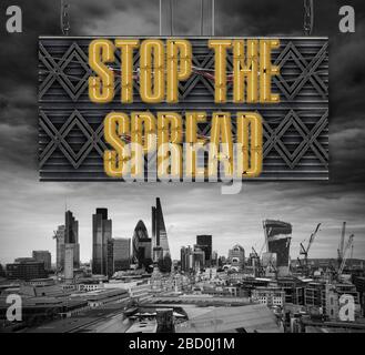 Floating neon type letters on frame hanging over City of London financial district square mile skyline reading Stop the Spread in relation to Coronavi Stock Photo