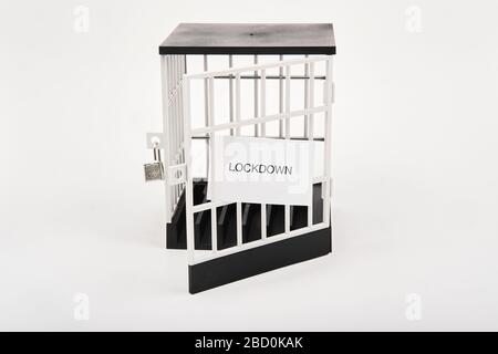 Coronavirus partial lockdown concept with unlocked jail and a lockdown sign sticking out of the jail bars Stock Photo