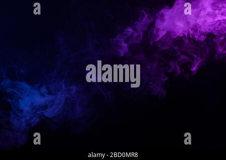 Dense multicolored smoke of blue, pink and purple colors on a black ...
