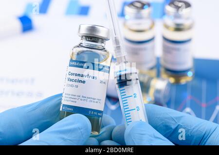 Coronavirus COVID-19 vaccine vial and injection syringe in scientist hands concept. Research for new novel corona virus immunization drug. Stock Photo