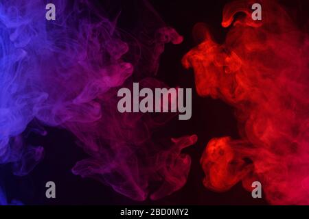 Multicolored smoke clouds flowing dark abstract background Stock Photo