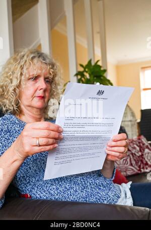 Brighton UK 6th April 2020 - A Brighton resident reads the governments coronavirus update letter sent to every household by Prime Minister Boris Johnson during the Coronavirus COVID-19 pandemic crisis  . Credit: Simon Dack / Alamy Live News
