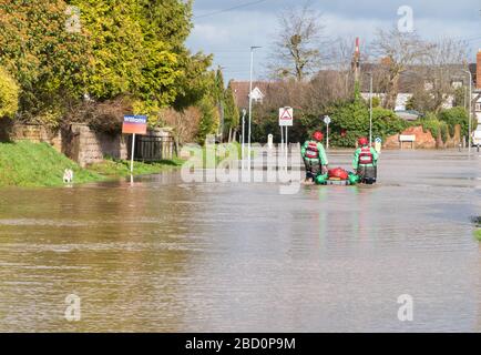 Emergency services carrying an iflatable boat through flood waters on Hinton road Hereford Herefordshire UK. February 2020. Stock Photo