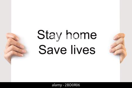 Hands holding a  board with the message Stay home Save lives, covid-19 coronavirus lockdown concept Stock Photo