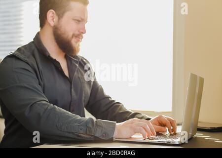 Young design engineer working with laptop in office, searching ideas. Stock Photo