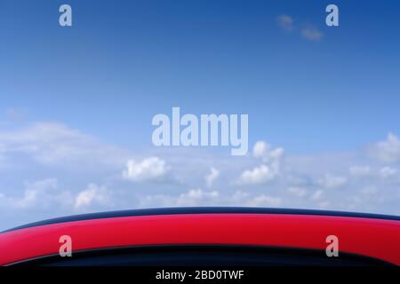 blue sky over roof of car in the foreground. Stock Photo