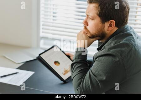 Closeup engineer using tablet and looking at graphs with diagrams on screen. Stock Photo