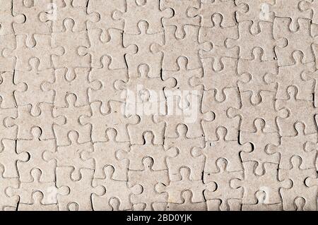 Abstract background formed by image of blank reverse side of a completed jigsaw puzzle. Stock Photo