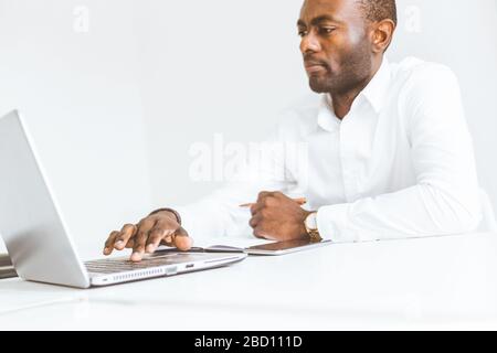 Young african American businessman working in the office at the laptop Stock Photo