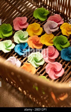 Origami paper flowers lie in a basket Stock Photo