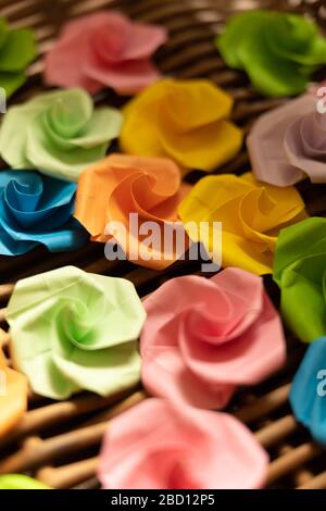 Origami paper flowers lie in a basket Stock Photo