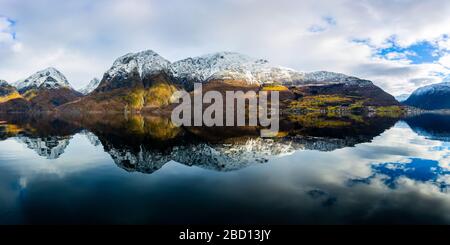 Snow-capped mountains reflected in a fjord, Norway Stock Photo