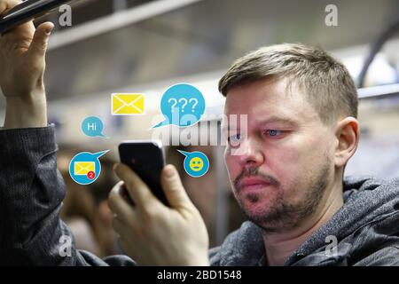 Handsome male using dating apps while traveling subway Stock Photo
